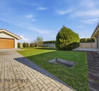 Einfamilienhaus in Kútniky mit Garage, Rasen und befestigter Zufahrtsstraße.