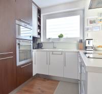 Küche in einer 3-Zimmer-Wohnung mit Holzboden und großem Fenster.