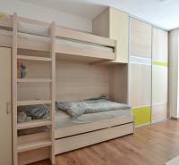 Etagenbett und Einbauschrank in einem Zimmer mit Holzboden.