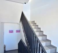 Eine Treppe mit weißen Wänden und Dekorationen in einer 3-Zimmer-Wohnung.