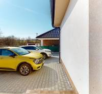 Ein gelbes Auto, das bei einem Einfamilienhaus in Horné Štitáre geparkt ist, sonniger Tag, Pflastersteine.