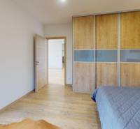 Schlafzimmer mit Schiebetürenschrank und Bodenbelag in Holzoptik im Einfamilienhaus.