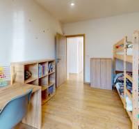 Kinderzimmer in einem Einfamilienhaus mit Holzboden, Etagenbett und Schreibtisch.