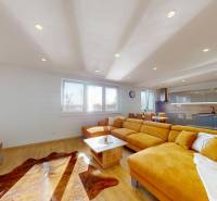 Wohnzimmer mit Holzboden und orangefarbenem Sofa in einem Einfamilienhaus.