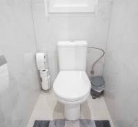 Badezimmer mit Toilette in einer 2-Zimmer-Wohnung, helle Fliesen und Accessoires in neutralen Farben.