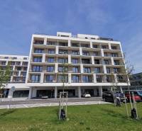 Wohnhaus in der Eduard-Wenzl-Straße mit Parkplätzen und Garagen im Vordergrund.