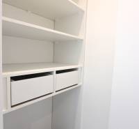 Weißer Kleiderschrank mit Schubladen und Regalen in einer 3-Zimmer-Wohnung.