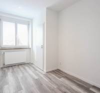 Helles Zimmer mit Holzboden und Fenster in einer 3-Zimmer-Wohnung.