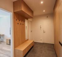 Eingangsbereich einer 3-Zimmer-Wohnung mit Fliesenboden und Holzelementen.