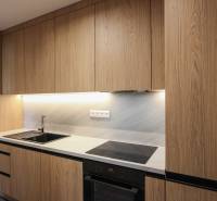 Küche in einer 3-Zimmer-Wohnung mit Holzelementen in der Küchenzeile und eingebauten Geräten.