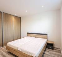 Schlafzimmer in einer 3-Zimmer-Wohnung mit Holzboden und einem großen Einbauschrank.