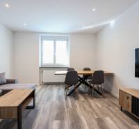 Wohnzimmer mit Holzboden, Sofa, Esstisch und Fernseher in einer 3-Zimmer-Wohnung.