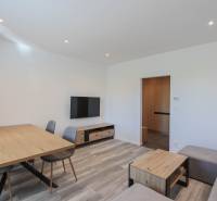 Wohnzimmer in einer 3-Zimmer-Wohnung mit Holzboden und Holzmöbeln.