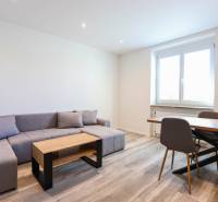 Wohnzimmer mit Ecksofa, Esstisch und Holzboden.