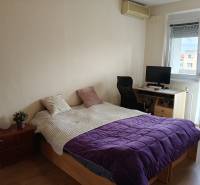 Schlafzimmer in einer 3-Zimmer-Wohnung mit Bett, Arbeitsecke und Boden mit Holzdekor.