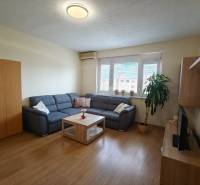 Wohnzimmer mit Ecksofa, Holzboden und Fernseher in einer 3-Zimmer-Wohnung.