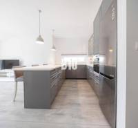 Küche in einer 3-Zimmer-Wohnung mit einem modernen Kühlschrank aus Stahl und einem Boden in Holzoptik.