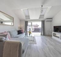 Wohnzimmer in einer 3-Zimmer-Wohnung mit Sofa und Holzboden.