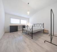 Ein Schlafzimmer mit einem Boden in Holzoptik und einem Bettgestell aus Metall in einer 3-Zimmer-Wohnung.