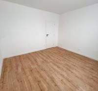 Ein leerer Raum mit hellen Wänden und einem Boden in Holzoptik, 3-Zimmer-Wohnung.