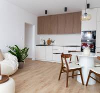Wohnzimmer mit Küche in einer 3-Zimmer-Wohnung mit Holzboden.
