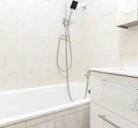 Badezimmer mit weißer Badewanne und Waschbecken in einer 2-Zimmer-Wohnung.
