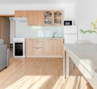 Küche in einer 2-Zimmer-Wohnung mit Holzboden und Esstisch.
