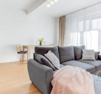 Helles Wohnzimmer mit Holzboden, bequemer Couch und Essecke.