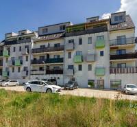 Ein Wohngebäude in der Vincent Šikula Straße in Stupava, umgeben von Autos und Grünflächen.