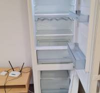 Otváracia Kühlschrank in einem Studio-Apartment mit Holzboden und kleinem Tisch.