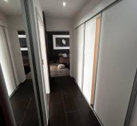 Der Flur in der 3-Zimmer-Wohnung mit dunklem Boden und Einbauschränken.