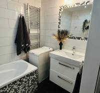 Elegantes Badezimmer mit Fliesen, Waschbecken und Badewanne, Teil einer 3-Zimmer-Wohnung.