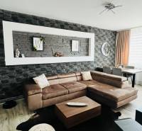 Wohnzimmer in einer 3-Zimmer-Wohnung mit Holzboden und Ecksofa.