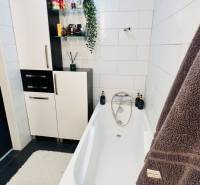 Badezimmer mit Badewanne, Schränken und Dekorationen in einer 3-Zimmer-Wohnung.