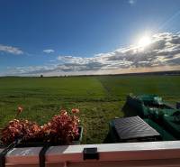 Ein Blick auf die weite grüne Landschaft und einen Balkon mit Blumen in Gbely.