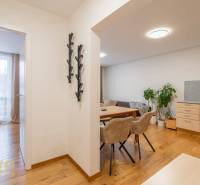 Innenraum einer Ferienwohnung mit Holzboden, Essbereich und Schlafzimmer.