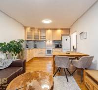 Wohnzimmer mit Küchenzeile in einer Ferienwohnung und einem Boden mit Holzdekor.
