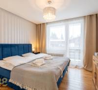 Schlafzimmer im Ferienapartment mit bequemem Bett und Boden in Holzoptik.