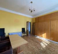 Obývacia izba s podlahou s dreveným dekorom, nábytkom a kreslami v rodinnom dome.