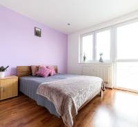 Schlafzimmer in einer 2-Zimmer-Wohnung mit Bett, Schrank und Boden in Holzoptik.