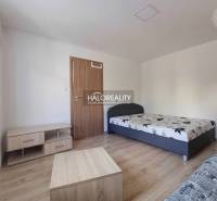 Einzimmerwohnung mit Bett und Möbeln auf einem Boden mit Holzdekor.