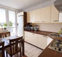 Küche in einer 4-Zimmer-Wohnung mit großem Fenster, Esstisch und hellen Möbeln.