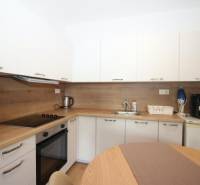Küche mit eingebauten Geräten und Holzelementen in einer Einzimmerwohnung.