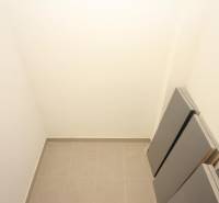 Ein kleiner Stauraum in einer Einzimmerwohnung mit Fliesenboden und weißen Wänden.