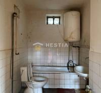 Badezimmer in einem Einfamilienhaus mit Badewanne, Boiler und Toilette.