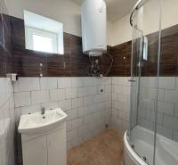 Ein Badezimmer in einem Einfamilienhaus mit einer modernen Dusche und hellen Fliesen.
