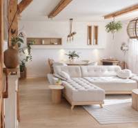 Wohnzimmer in einem Einfamilienhaus mit großem Sofa und Boden in Holzoptik.