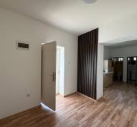 Ein Einfamilienhaus mit weißen Wänden und einem Boden in Holzoptik, geräumiger Eingangsbereich.