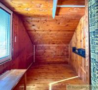 Ein Raum in einer Hütte mit einem Holzboden und einem Dachfenster.