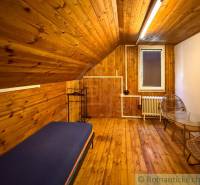 Innenraum einer Hütte mit Holzboden, Bett und Stühlen für Komfort.